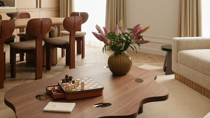 Salon avec table basse sculpturale, canapé en tissu texturé et jeu d’échecs en bois