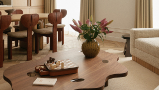 Salon avec table basse sculpturale, canapé en tissu texturé et jeu d’échecs en bois