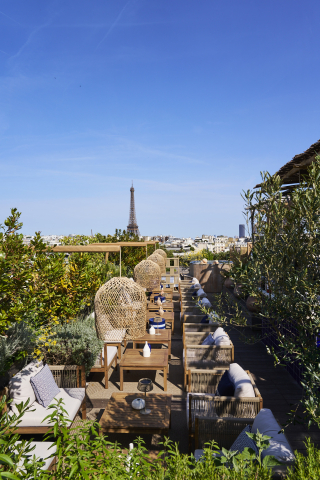 Terrasse de la Villa Minuty au Brach Paris : lanternes en osier, végétation luxuriante et panorama d’exception sur les toits parisiens.