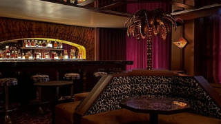 Bar du Palacio avec lampe en forme de palmier et banquettes imprimé léopard