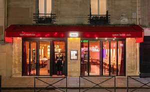 Façade du restaurant Buenas à Paris, devanture rouge avec enseigne lumineuse, intérieur coloré et ambiance chaleureuse inspirée de l’univers d’Almodóvar