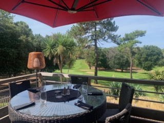 Table en terrasse du Bistrot du Golf avec vue sur les greens et la pinède