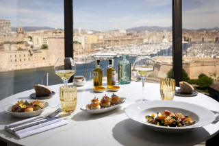 Table dressée au restaurant Les Trois Forts avec plats gastronomiques et vue sur le port