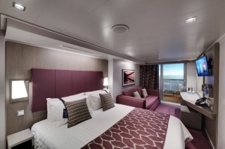 Cabine spacieuse avec lit double, canapé et balcon donnant sur la Méditerranée à bord du MSC Seaside