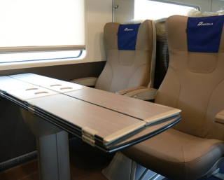 Classe Business de Trenitalia Frecciarossa, avec des sièges doubles confortables et une table.