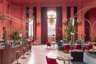 Intérieur du restaurant de la Casa de las Artes à Madrid, avec ses voûtes rouges et ses vitraux d’inspiration classique.