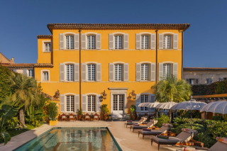 Façade ensoleillée du Pan Deï Palais à Saint-Tropez, avec sa piscine et son jardin méditerranéen.