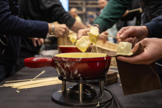 Des participants dégustent une fondue au fromage lors de l’événement.