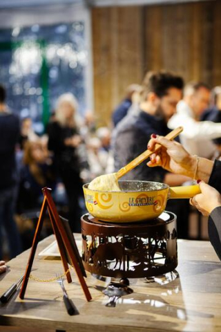 Un chef montre la préparation du fromage fondu Le Gruyère.