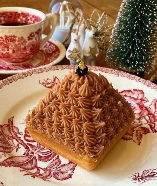 Dessert en forme de pyramide à la crème de marrons signé Muscade L’Atelier, présenté sur une assiette décorative dans une ambiance festive.