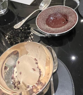 Glace au lait fermier avec éclats de cacao accompagnée d’un gâteau au chocolat chaud servi dans un petit poêlon.