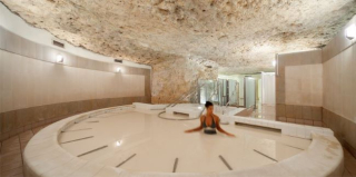 Bain de kaolin blanc dans l’espace troglodytique des Thermes de Jonzac, avec une curiste en soin