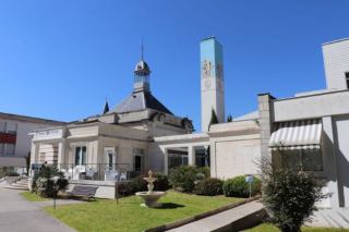 Façade historique des Thermes de Saujon, avec son pavillon et son clocher sous un ciel bleu