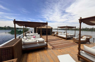 Solarium aménagé sur le pont d’un bateau, avec lits de repos et vue sur le Nil.