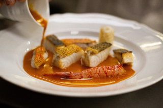 Une sauce versée sur des filets de poisson chez Piero à Paris.